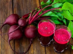 Glass Of Fresh Beetroot Juice With Bets On Wooden Table